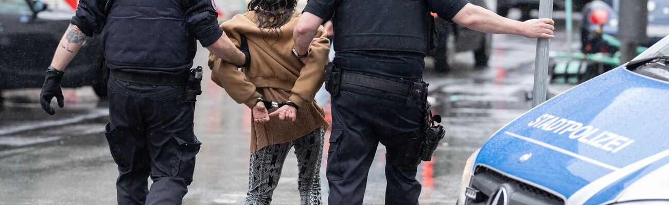 Polizisten haben einer Frau bei ihrer Festnahme Handschellen angelegt, nachdem diese sich mit einer anderen Frau auf offener Straße im Bahnhofsviertel geprügelt hatte., © Boris Roessler/dpa