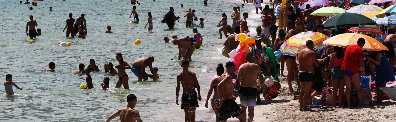 Zahlreiche Menschen sind am Strand von Mondello auf Sizilien zu sehen. Italien leidet besonders unter Übertourismus., © Alberto Lo Bianco/LaPresse via ZUMA Press/dpa