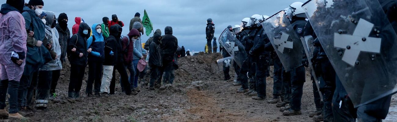 Polizisten stehen Demonstranten am Rande des Braunkohletagebaus bei Lützerath gegenüber (Archivfoto), © Oliver Berg/dpa