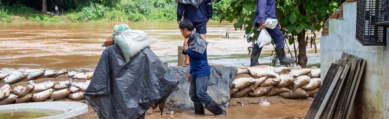 Mit Sandsäcken versuchten Helfer, die Fluten aufzuhalten., © Pongmanat Tasiri/SOPA Images via ZUMA Press Wire/dpa