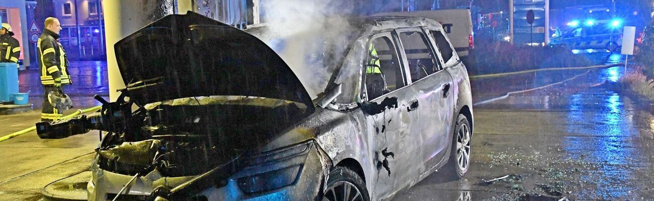 Ein ausgebranntes Autowrack steht an einer Tankstelle in Gütersloh. Auf dem Beifahrersitz wurde eine Tote gefunden., © Andreas Eickhoff/dpa