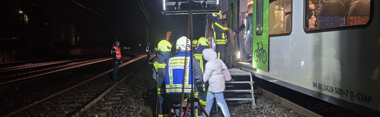 Feuerwehrleute helfen Reisenden, einen liegen gebliebenen Zug zu verlassen., © Feuerwehr Schwelm/dpa