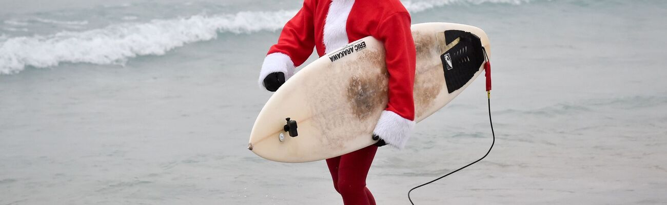 Events mit surfenden Weihnachtsmännern gibt es mittlerweile in mehreren Ländern. (Archivbild), © Ben Birchall/PA Wire/dpa