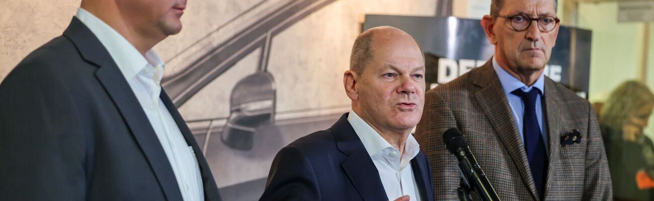 Betriebsratschef Benjamin Gruschka (l) neben Bundeskanzler Olaf Scholz (SPD) und Marcus Wassenberg (r), Geschäftsführer der Ford-Werke., © Christoph Reichwein/dpa