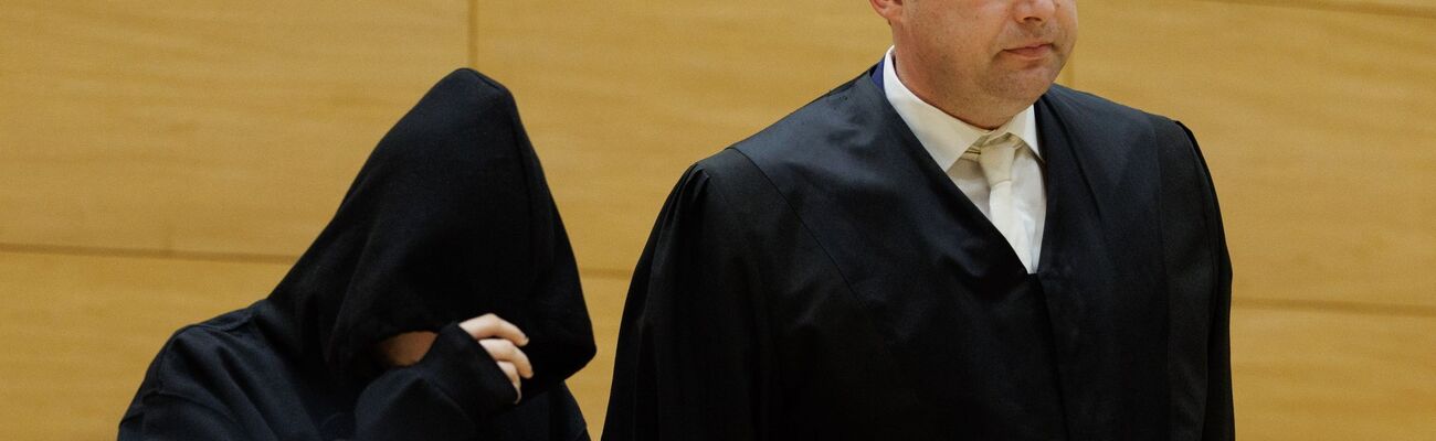 David Volke (r), der Verteidiger der Angeklagten, steht neben seiner Mandantin in einem Saal des Landgerichts zum Auftakt im Prozess um ein getötetes Baby. (Archivbild), © Friso Gentsch/dpa