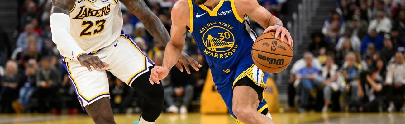 LeBron James (l) und die Los Angeles Lakers setzten sich bei den Golden State Warriors um Stephen Curry durch., © Eakin Howard/AP/dpa