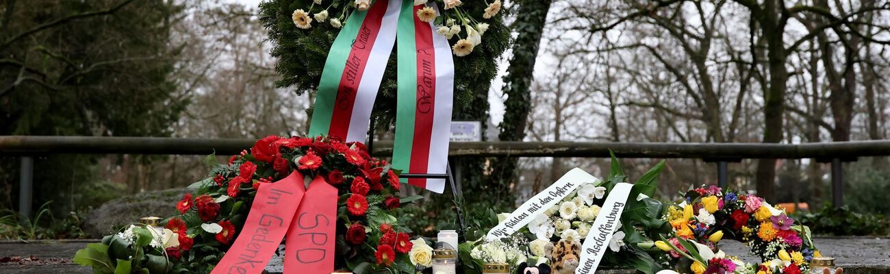 Menschen haben Blumen niedergelegt., © Daniel Löb/dpa