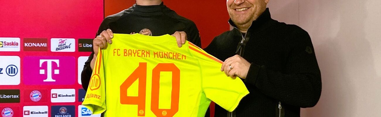 Jonas Urbig (l) präsentiert das Bayern-Trikot mit der Nummer 40 bei seiner Vorstellung mit Sportvorstand Max Eberl., © Klaus Bergmann/dpa