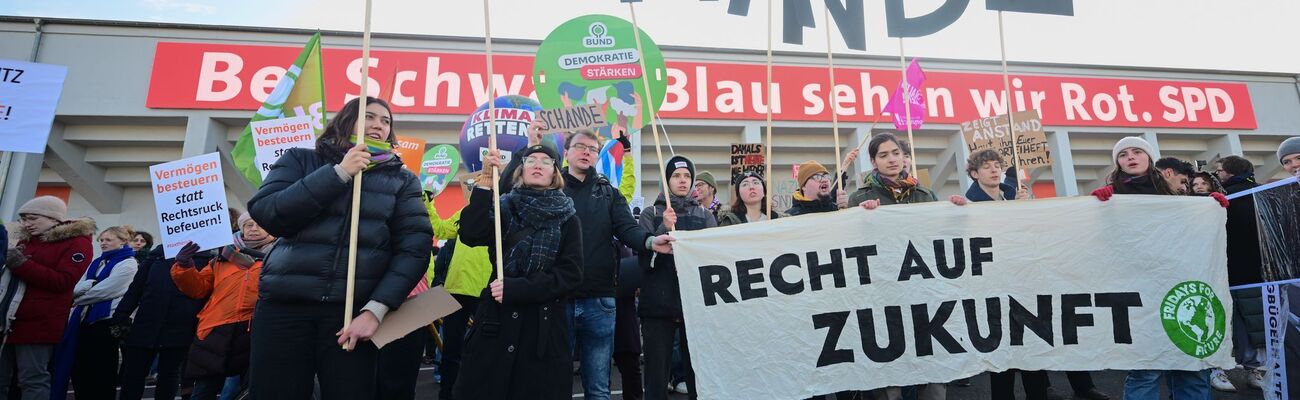 Zum Parteitag demonstrieren mehrere Menschen vor dem Gebäude. , © Sebastian Christoph Gollnow/dpa