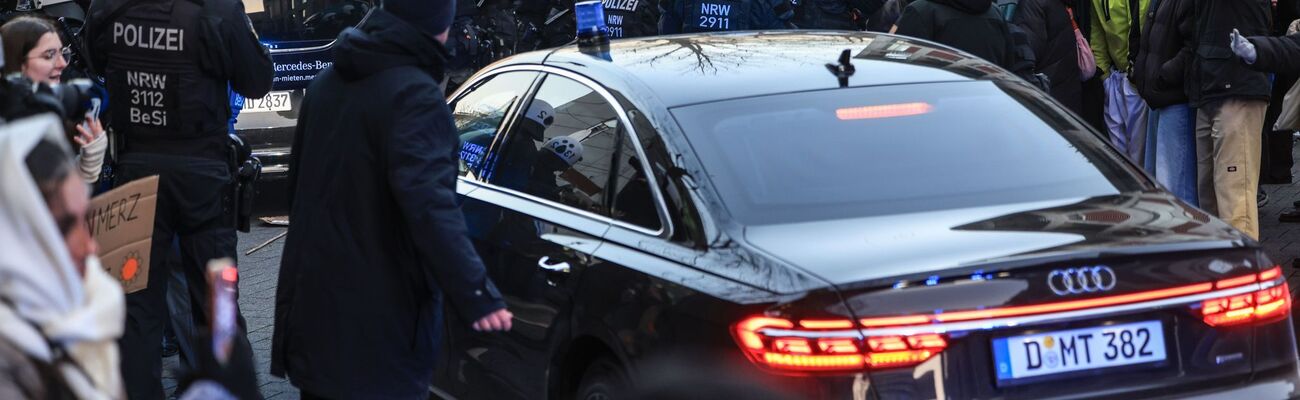 Polizisten schieben Demonstranten beiseite, damit Autos das Geländer der Kölner Uni-Klinik verlassen können., © Oliver Berg/dpa