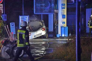 Ein Feuerwehrmann geht auf das Gelände der Tankstelle, auf dem in der Nacht ein Fahrzeug in Brand geraten war. , © Andreas Eickhoff/dpa