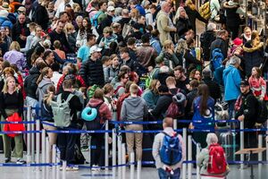 Am Flughafen in Düsseldorf stehen Reisende am Samstagmorgen mit ihren Koffern im Abflug-Terminal vor den Check-In-Schaltern., © Christoph Reichwein/dpa