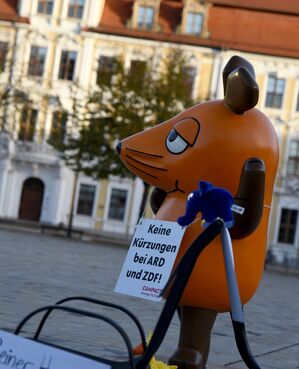 Die von Aktivisten "entführte" Maus protestiert in Magdeburg gegen Kürzungen beim öffentlich-rechtlichen Rundfunk. , © Simon Kremer/dpa