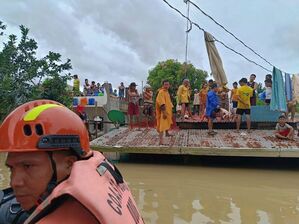 Viele mussten lange auf ihren Dächern ausharren, bis Helfer sie erreichten. , © Uncredited/Philippine Coast Guard/AP/dpa