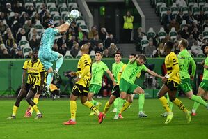 Viel los im Wolfsburger Strafraum: Torwart Kamil Grabara hält den Ball., © Swen Pförtner/dpa