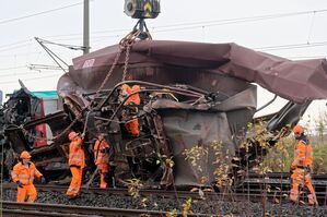 Arbeiter befestigen den demolierten Güterwaggon an einem Kran., © Henning Kaiser/dpa