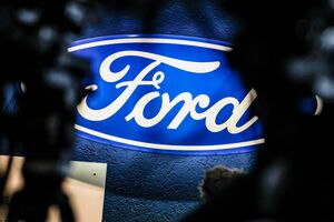 Ein beleuchtetes Firmenschild des Autobauers Ford leuchtet am Rande einer Betriebsversammlung am Standort Köln., © Christoph Reichwein/dpa