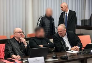 Der Hauptangeklagte (hinten, links) spricht im Gerichtssaal mit seinem Verteidiger Oliver Doelfs (hinten, rechts)., © Oliver Berg/dpa