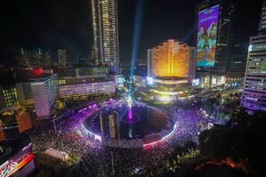 Menschen versammeln sich in der Silvesternacht im Hauptgeschäftsviertel in Jakarta., © Tatan Syuflana/AP/dpa