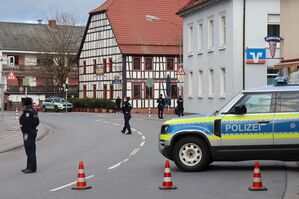 Polizeibeamte sichern die Straße rund um die Bankfiliale., © René Priebe/PR-Video/dpa