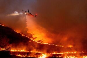 Ein Hubschrauber wirft Wasser über dem «Kenneth Fire» ab., © Ethan Swope/AP/dpa