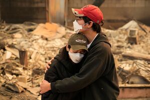 Ari Rivera (r) und Anderson Hao umarmen sich vor ihrem zerstörten Haus in Altadena. Viele Menschen haben ihr gesamtes Hab und Gut verloren. , © John Locher/AP/dpa