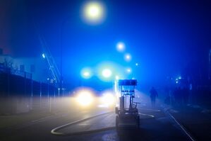 Im dichten Nebel flackert das Blaulicht der Feuerwehrautos bei den Löscharbeiten., © Christoph Reichwein/dpa